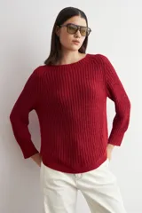 Sweater de punto con textura jaspeada en tonos marrones, de corte recto, cuello redondo y mangas largas. Presenta un diseño con ruedo curvo.