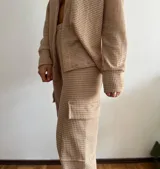 Pantalón cargo color beige de tejido waffle, corte recto y bolsillos laterales.