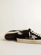 Zapatillas Golden Goose modelo Hi Star, de color negro con plataforma, confeccionadas en gamuza con detalles de glitter plateado en la estrella lateral y el talón.