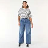 Jean de corte wide leg en color azul medio, con diseño de tiro alto y bajos deshilachados.