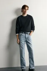Pantalón jeans de corte recto, color celeste claro con efecto lavado, de cinco bolsillos y tiro medio.
