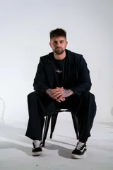 Blazer de lycra color negro, de corte oversize y diseño estructurado con solapas clásicas. Presenta detalles bordados sutiles en la solapa y en el puño de la manga.