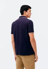 Chomba negra de manga corta con cuello camisero, cartera de botones y detalle bordado en el pecho.