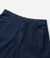 Bermuda tipo jorts de corte amplio y tiro medio, confeccionada en denim de algodón azul oscuro. Presenta diseño de cinco bolsillos, cierre frontal con botón y costuras en tono contrastante.