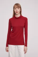 Polera de viscosa color rojo, de corte ajustado al cuerpo, con cuello alto y mangas largas.