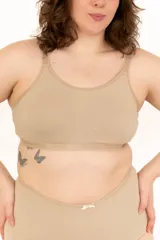 Top básico confeccionado en algodón elastizado color beige, con tirantes elásticos regulables y escote redondo.