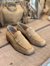 Mocasín de gamuza con textura efecto croco, color beige, con costuras reforzadas en el empeine y suela plana.