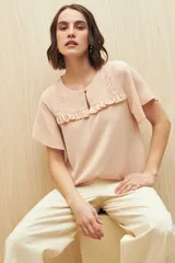 Blusa negra con textura, canesú con encaje, volados, corte fluido y mangas cortas amplias.