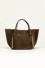 Bolso tote de gamuza marrón con doble asa corta y tiras decorativas anudadas a los costados.