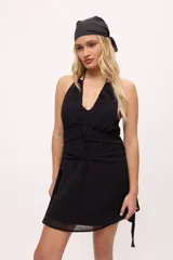 Vestido corto color borgoña, con escote halter, tiras finas y detalle de lazos en la cintura.