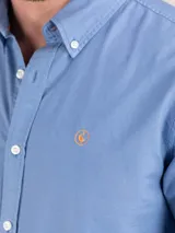 Camisa lisa de hombre confeccionada en algodón, tintada en prenda con acabado vintage. Presenta corte regular fit, cuello buttondown, cierre frontal de botones, manga larga con puño simple y logo bordado en el pecho.