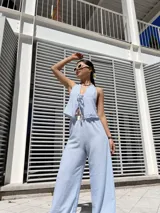 Pantalón celeste a rayas verticales blancas, de corte palazzo y cintura alta con elástico.