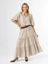 Falda larga de estilo campesino, color beige con sutil estampado, de diseño amplio con volantes y cintura elastizada.