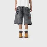 Bermuda baggy de denim color negro con efecto acid wash, corte holgado y diseño cargo con múltiples bolsillos.