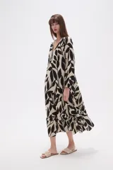 Vestido midi holgado con estampado floral en tonos verde militar y beige, cuello en V, mangas largas y falda con volados.