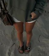 Sandalia marrón de cuero con hebilla metálica plateada y plantilla de cuero.