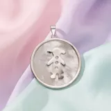 Dije circular de plata 925 con incrustación de nácar y silueta de niña grabada en el centro.