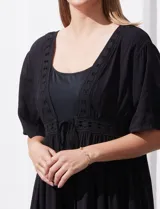 Kaftan de color blanco con apliques de puntilla en el escote y la cintura. Presenta una abertura central con lazo para atar, mangas cortas amplias y un diseño fluido de marca Barrington.