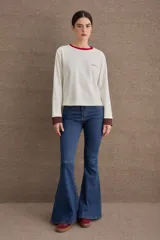 Remera de manga larga color marrón, con cuello en tono verde claro y puños en tono celeste. Presenta el logo de la marca bordado en el pecho.