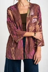 Kimono de viscosa con estampado abstracto en tonos marrones, violetas y verdes, con detalles de hilos dorados y mangas tres cuartos.