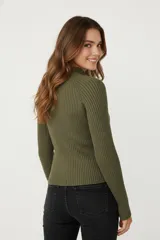 Polera de viscosa color beige claro, de tejido canalé, corte ajustado al cuerpo y cuello alto.