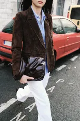 Blazer de ante color marrón, con cuello solapa, hombreras, manga larga y cierre frontal cruzado con botones. Cuenta con bolsillos delanteros de doble vivo.