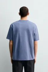 Camiseta de corte regular confeccionada en tejido de algodón compacto, con cuello redondo y manga corta.