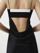 Vestido largo midi negro con breteles finos y escote recto con detalle blanco.