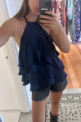 Top color beige claro con escote halter y tres volados. Incluye una rosa de tela removible en el cuello.