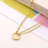 Collar dorado con cadena de eslabones rectangulares y cadena doble de bolitas. Dije circular.