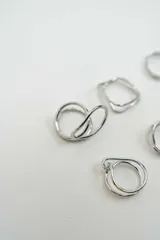 Set de seis anillos de metal plateado con diversos diseños, incluyendo formas geométricas, minimalistas y de estilo alambre.