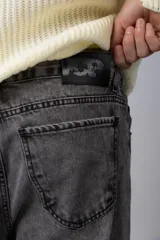 Jean de corte mom fit en color gris lavado, confeccionado en denim resistente, con diseño de tiro medio y ajuste holgado en las piernas.