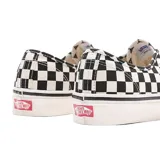 Championes Vans modelo Authentic 44 DX con diseño de tablero de ajedrez en blanco y negro. Presentan cordones blancos, suela de goma vulcanizada y etiqueta de la marca en el lateral.