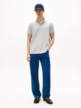 Chomba gris de corte regular confeccionada en tejido interlock de algodón suave. Cuenta con cuello de chomba, billetera de dos botones, raya a contraste en el cuello y logo del monotipo Hilfiger bordado en el pecho.