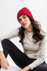 Gorro de lana tejido color lila con etiqueta negra con logo en el frente.