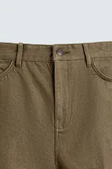 Pantalón de algodón color verde oliva, de corte recto (regular fit), con tiro medio, cierre frontal de cremallera y botón, y cinco bolsillos.
