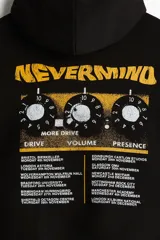 Canguro negro de mezcla de algodón con interior cepillado suave, capucha forrada y bolsillo canguro. Presenta hombros caídos y remate acanalado en puños y bajo. Estampado frontal con el logo de "Nirvana" en blanco y "Nevermind" en amarillo.