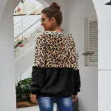 Campera tipo polar con cierre frontal, diseño combinado con estampado animal print en la parte superior y tejido de peluche blanco en la parte inferior. Cuenta con capucha con cordones ajustables y dos bolsillos frontales.