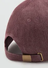 Gorra tipo baseball color bordó, confeccionada en algodón con efecto lavado. Presenta visera curva, mensaje bordado sutil en el frente y cierre posterior regulable con hebilla metálica.