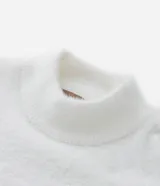 Suéter color beige de punto con textura de pelitos, cuello alto y mangas largas.