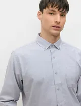 Camisa de manga larga de tejido Oxford color celeste, con cuello button-down, cierre frontal de botones y un bolsillo aplicado en el pecho.