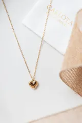 Collar dorado con dije en forma de corazón.