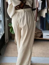 Pantalón de pana fina color beige, con cintura elástica y bolsillos laterales, de corte amplio y holgado.