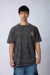 Remera de corte semi-oversize en color naranja con efecto de lavado tipo snow. Presenta un pequeño estampado gráfico en el pecho y cuello redondo.