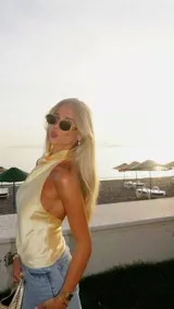 Top de satén color amarillo pastel, con diseño de cuello halter y espalda descubierta. Presenta una caída fluida y elegante, con un corte minimalista que se ajusta suavemente al cuerpo.