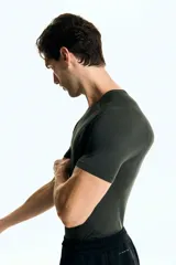 Remera deportiva de hombre, color verde oscuro, de tejido funcional DryMove™ con textura microperforada. Presenta cuello redondo y mangas raglán con costuras planas. Corte ajustado (Muscle Fit).