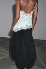 Pantalón blanco de tiro alto con cintura elástica ajustable mediante lazada interior. Presenta bolsillos laterales y un bajo con mucho volumen.