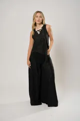 Pantalón negro súper campana de tiro medio en lino con bordados, con bolsillos delanteros y en la espalda. Cierre frontal con cremallera y botón.