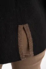 Polera de punto con calce oversize, cuello alto y mangas largas. Presenta un diseño en color negro con franjas laterales en las mangas y detalle en el cuello en tono bronce con acabado brillante.