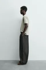 Camiseta de corte relajado (relaxed fit) color blanco roto o crema, con cuello redondo y manga corta.